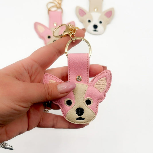 Charm Chihuahua in ecopelle rosa con moschettone dorato, tenuto in mano