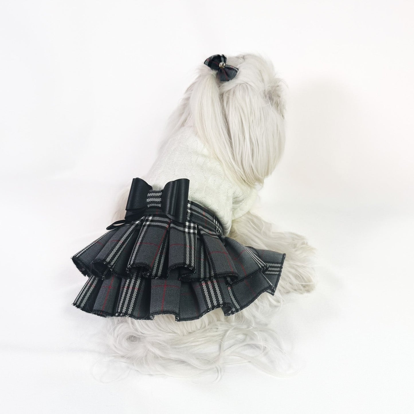 Abito per cane di piccola taglia con maglia panna a collo alto e gonna a balze in tessuto scozzese grigio con fiocco nero centrale