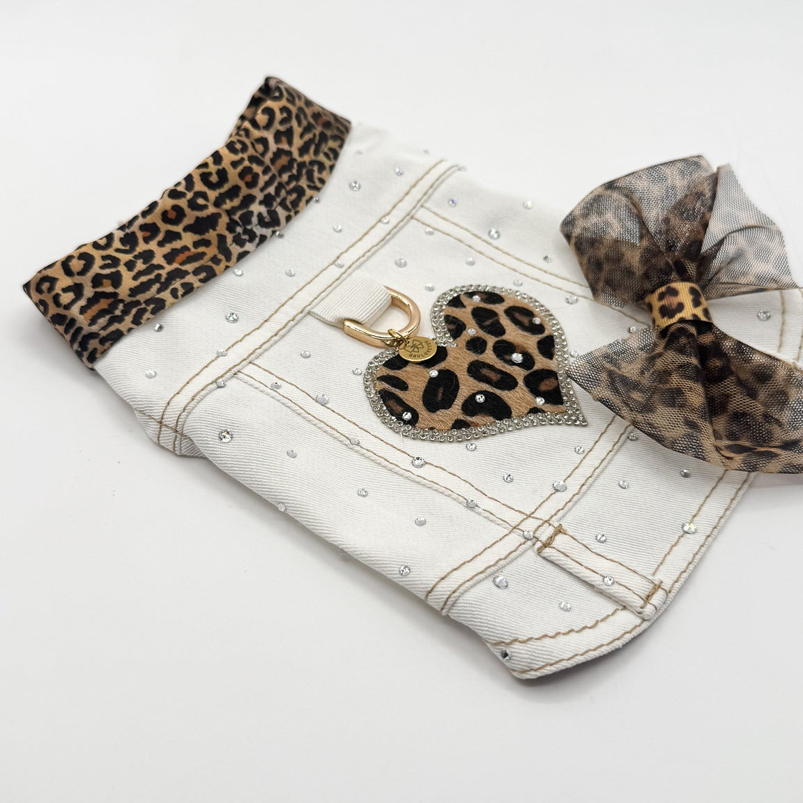 Dettaglio BauJeans Selvaggia in jeans bianco con cuore maculato, cristalli e fiocco removibile