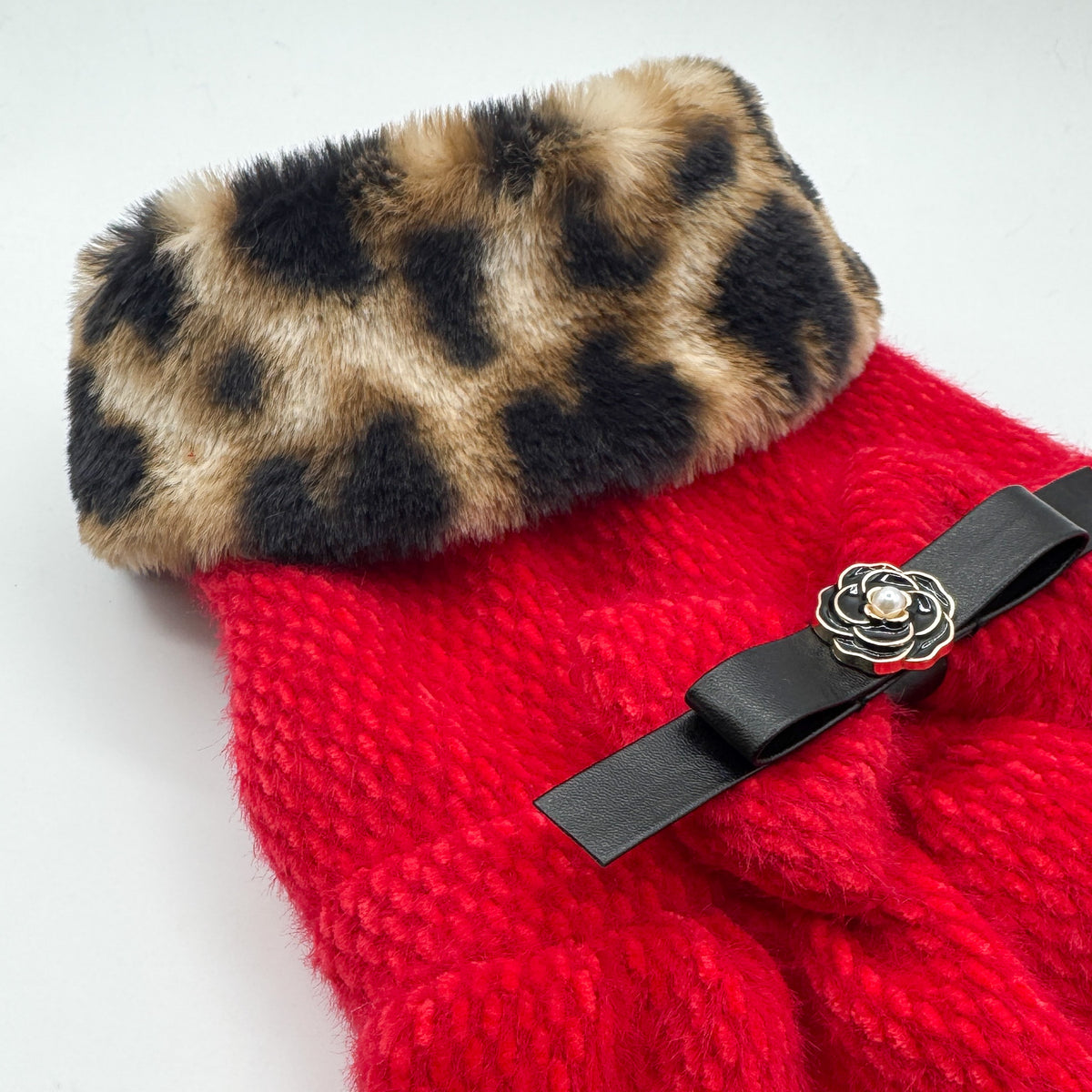 Dettaglio del Cappottino Ruby, collo in peluche leopardato e fiocco in ecopelle nera con bottone gioiello a fiore