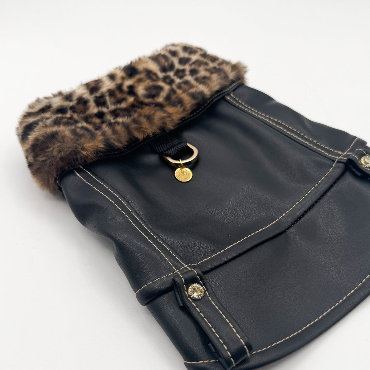 Dettaglio del collo in pelliccia leopardata del BauJeans Rebel con anello e charm dorato Bauloveyou