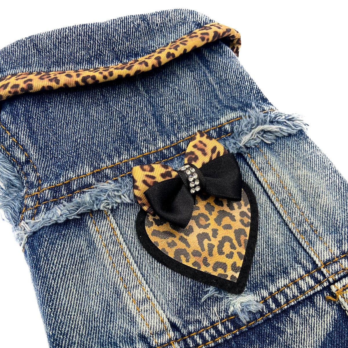 Dettaglio del cuore in similpelle maculato con fiocco e strass sul BauJeans Wild