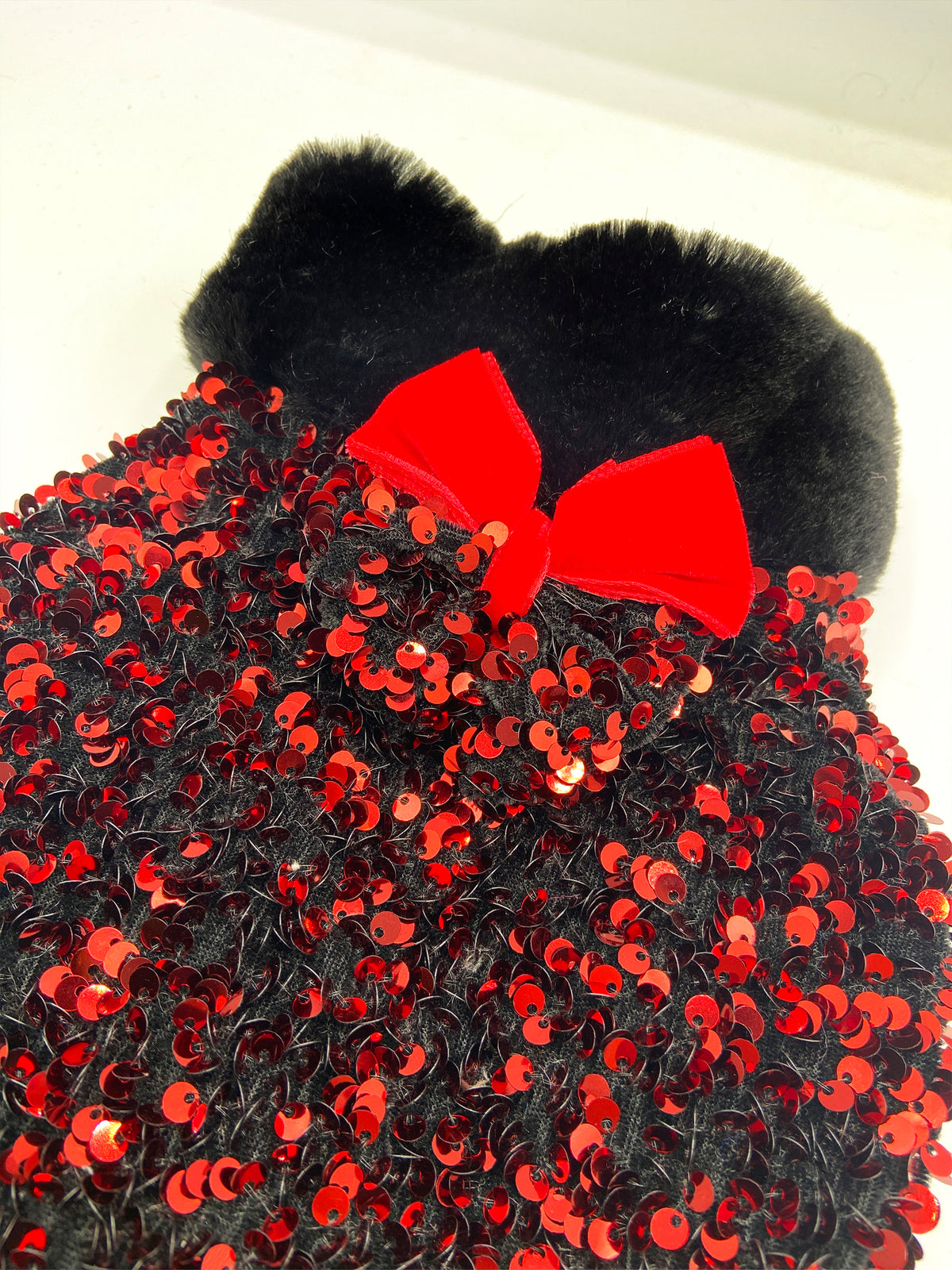 Dettaglio delle paillettes rosse e del fiocco in velluto rosso dell'Althena