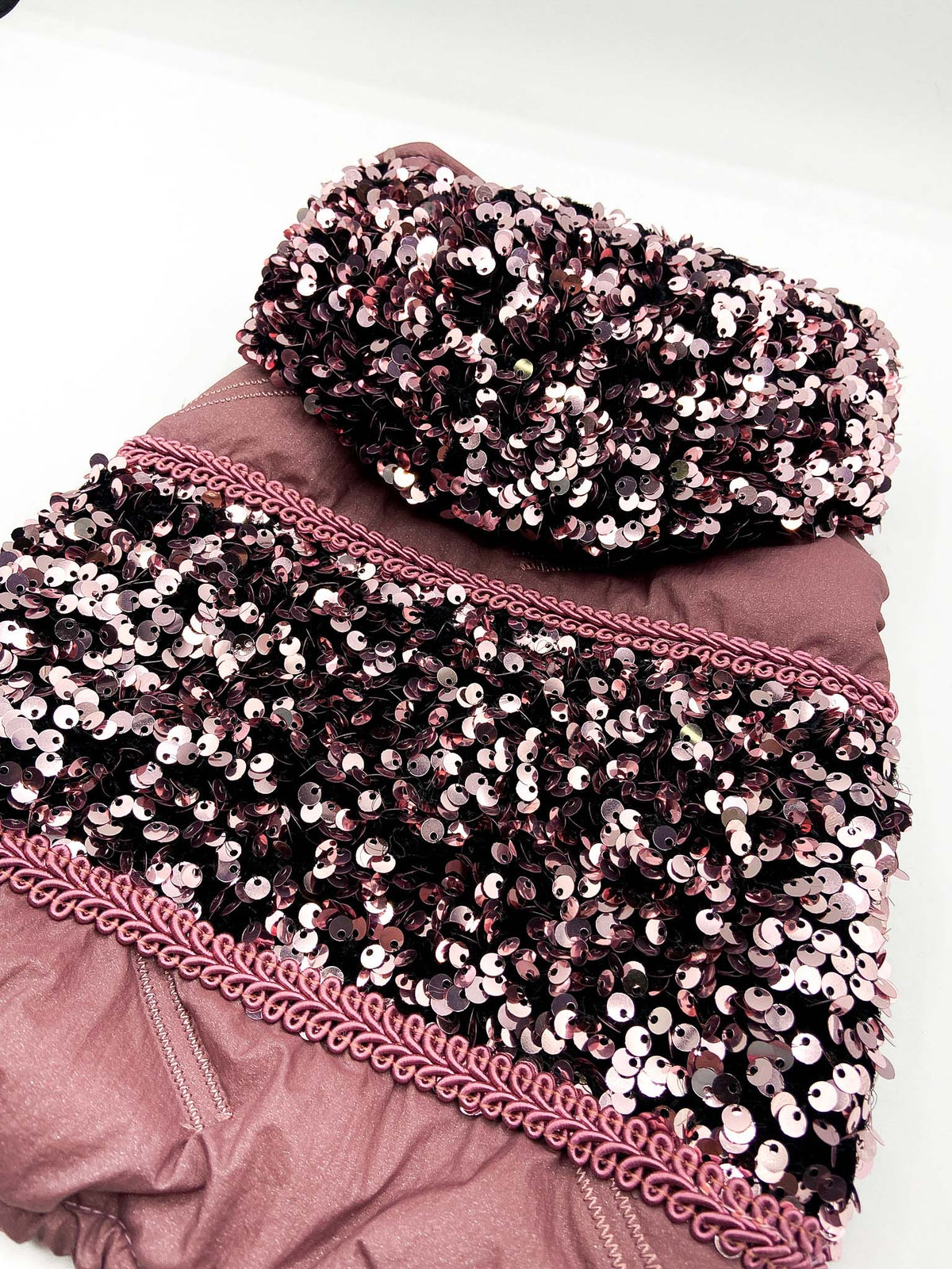Dettaglio del cappuccio e della banda in paillettes rosa del Piumino Sestante